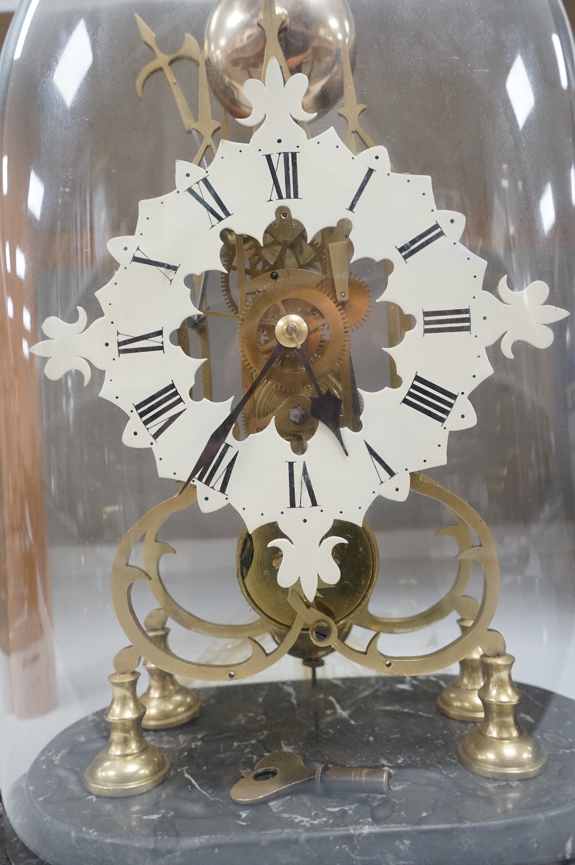 A large skeleton clock under dome, on grey marble base. 44cm high